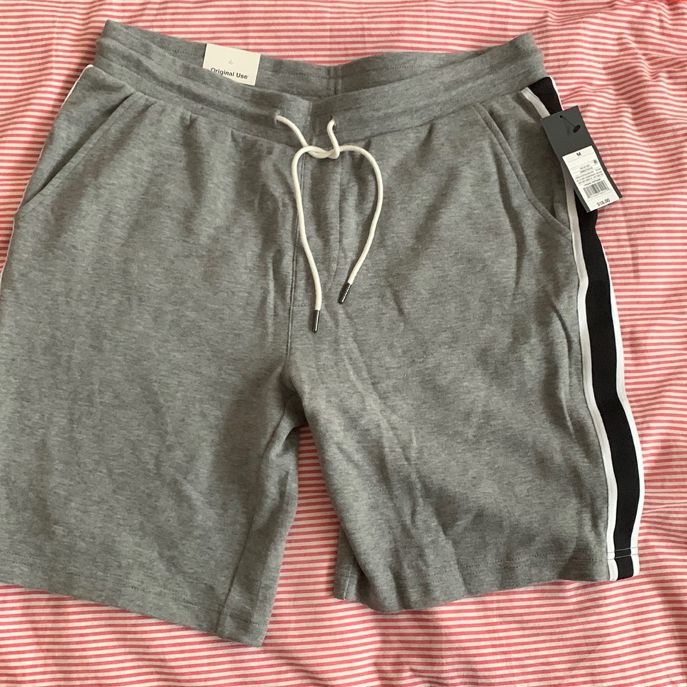 Grey Fleece Shorts with a Black and white stripe on the side for play.